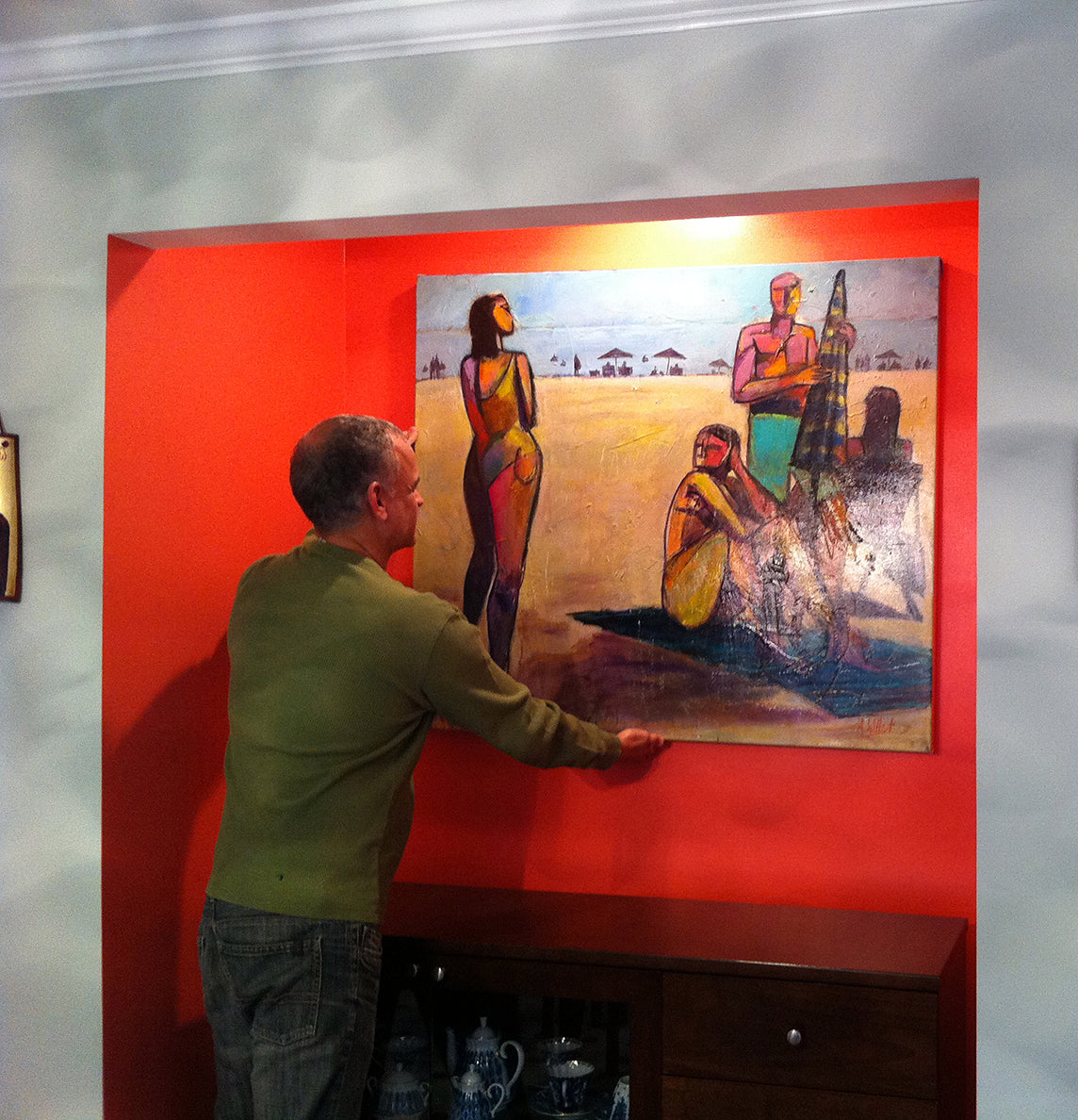 Westport CT collector hangs beach painting in a beautiful red alcove in their living room